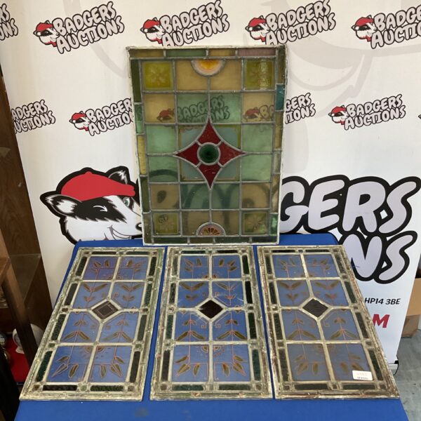 Four vintage stained glass window panels with a floral design.