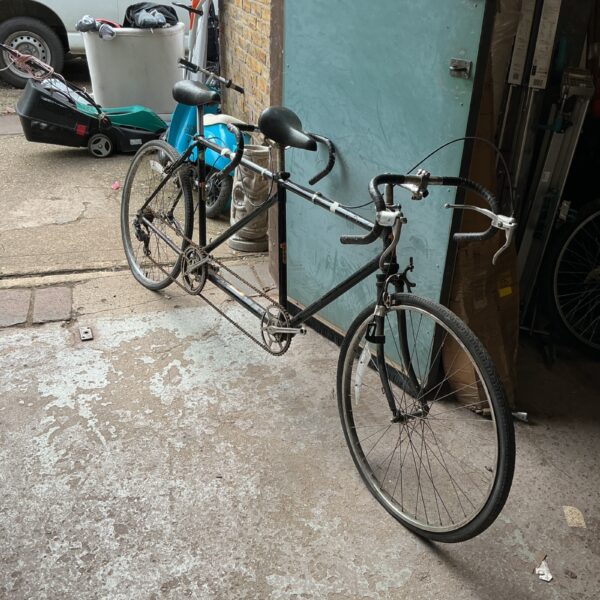 Side view of a vintage tandem bicycle for restoration.