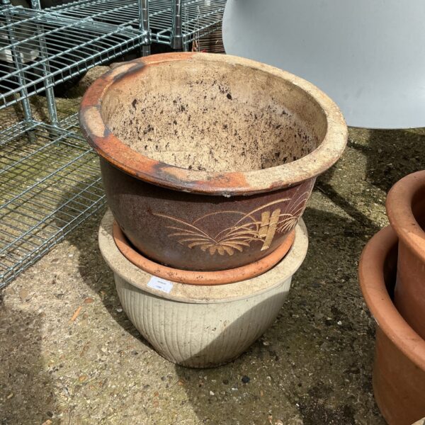 Three vintage terracotta garden planters with floral detailing.