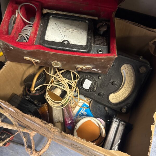 Vintage test meter in a red carrying case, electrical testing equipment.