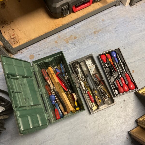 Vintage green tool box filled with various screwdrivers and hand tools.