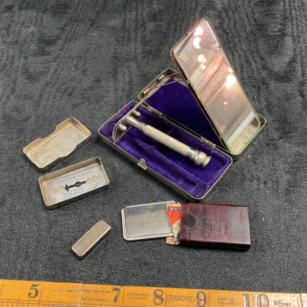 Open vintage travel razor set with mirror and razor.