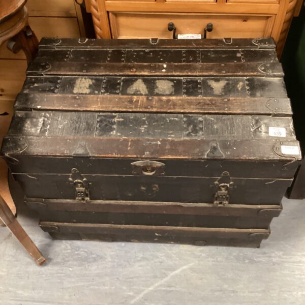 Side view of a vintage travel trunk with metal banding.
