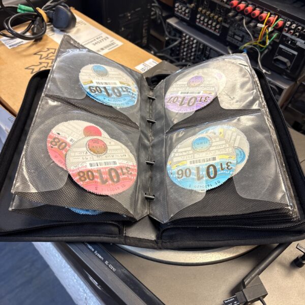 Vintage vehicle tax discs in a protective folder.