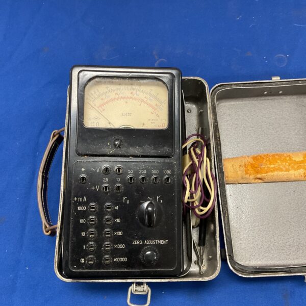 Vintage voltmeter model 437 with metal case and clear dial.