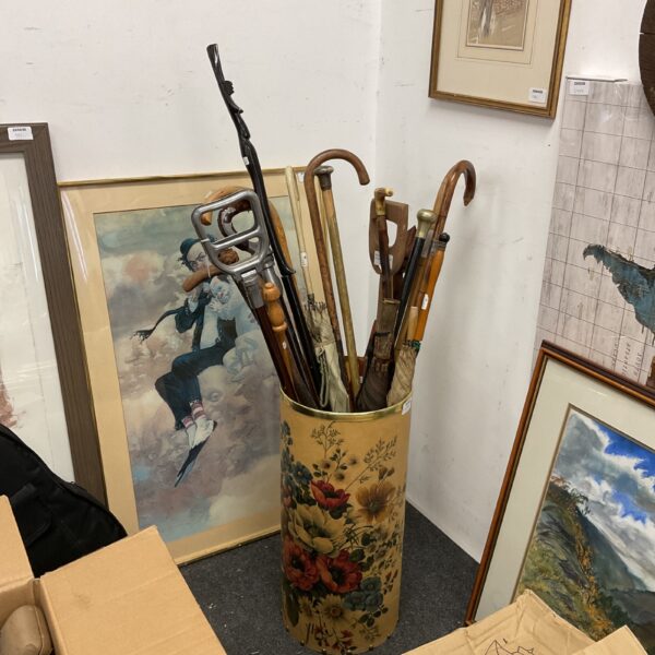 Vintage walking sticks and umbrellas in a floral patterned stick stand.