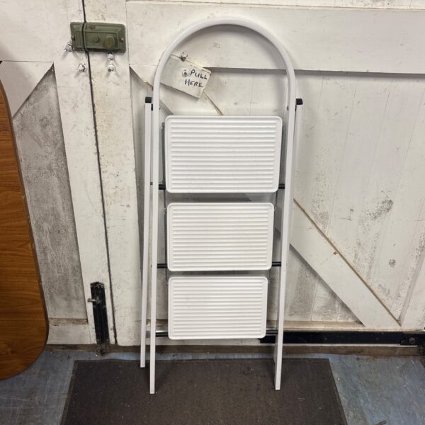 Vintage white folding step ladder for household use.