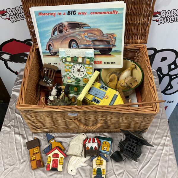 Vintage wicker hamper filled with collectible wooden houses and a Morris Minor print.