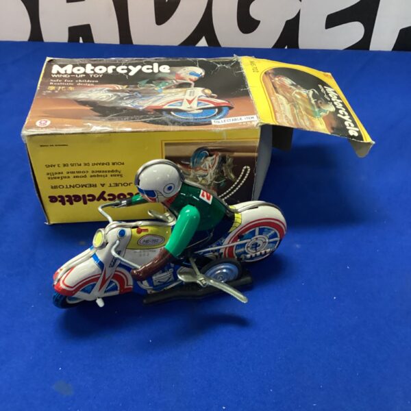 Vintage wind-up motorcycle toy, red and silver metal.
