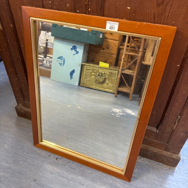 Vintage wood framed mirror with metal border for home decor.