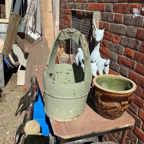 Weathered vintage wooden bucket with handle, rustic farmhouse style.