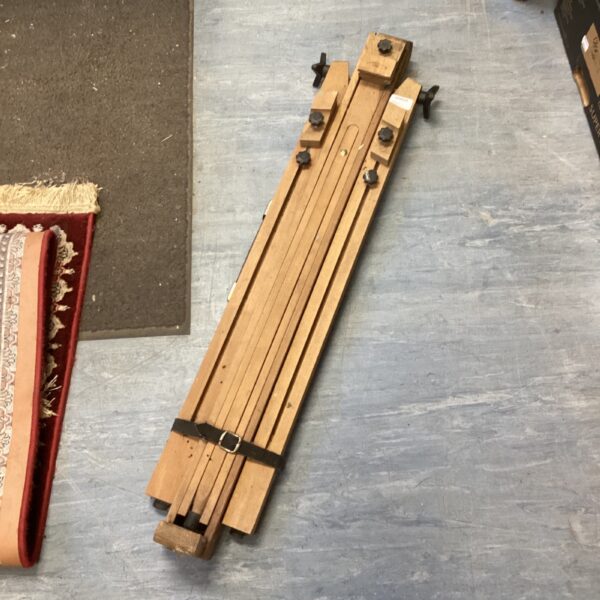 Vintage wooden easel with adjustable supports for painting.