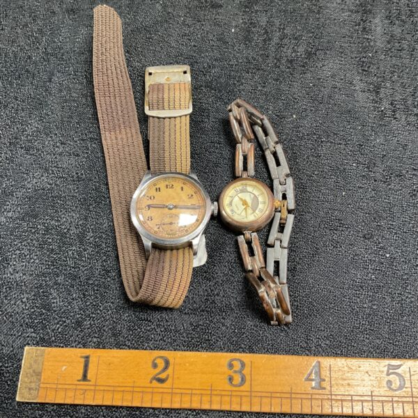 Pair of vintage wristwatches with canvas straps and cream dials.