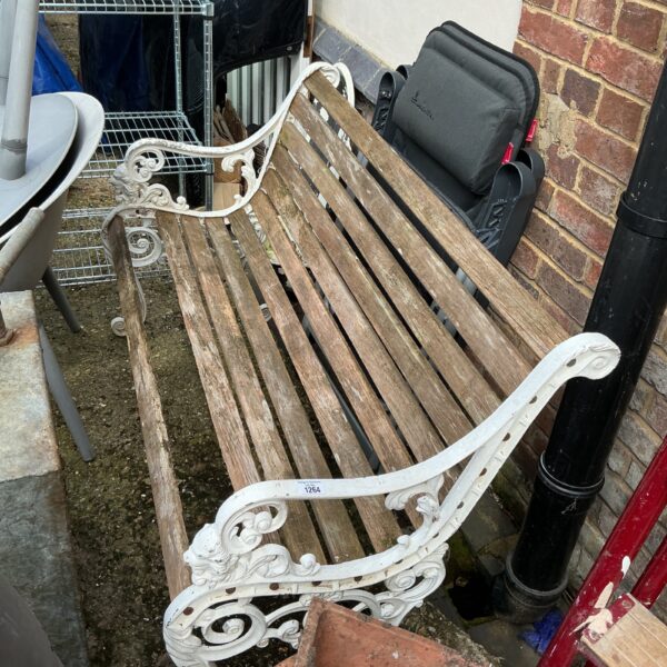 Vintage wrought iron garden bench needing repair for garden seating.