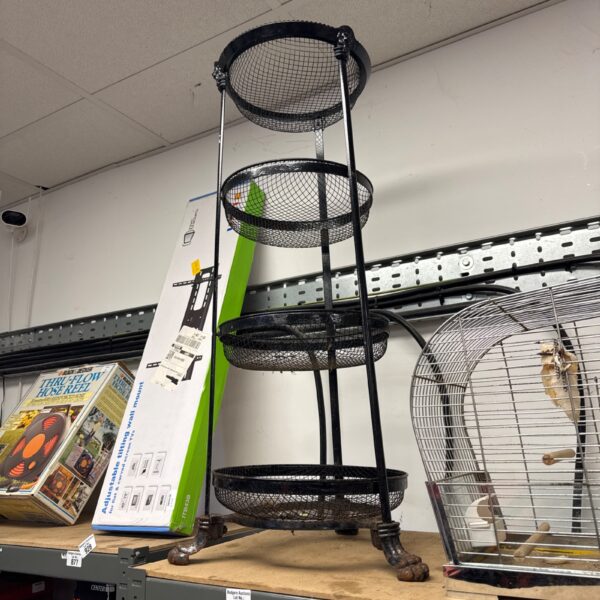 Vintage wrought iron tiered plant stand with claw feet.