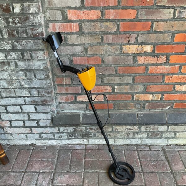 Vintage yellow metal detector for treasure hunting.