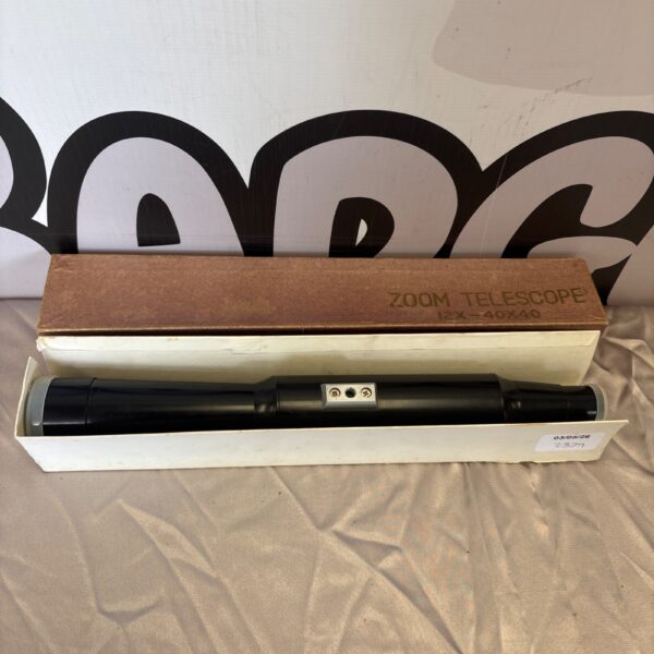 Vintage zoom telescope with 12x-40x magnification, side view.