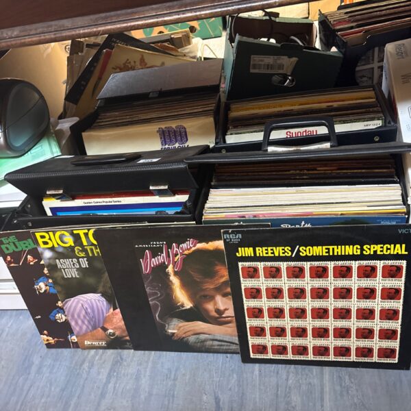 Mixed vinyl record collection with David Bowie records visible.