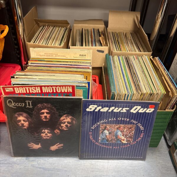 Large vinyl record collection featuring Queen and Status Quo albums.