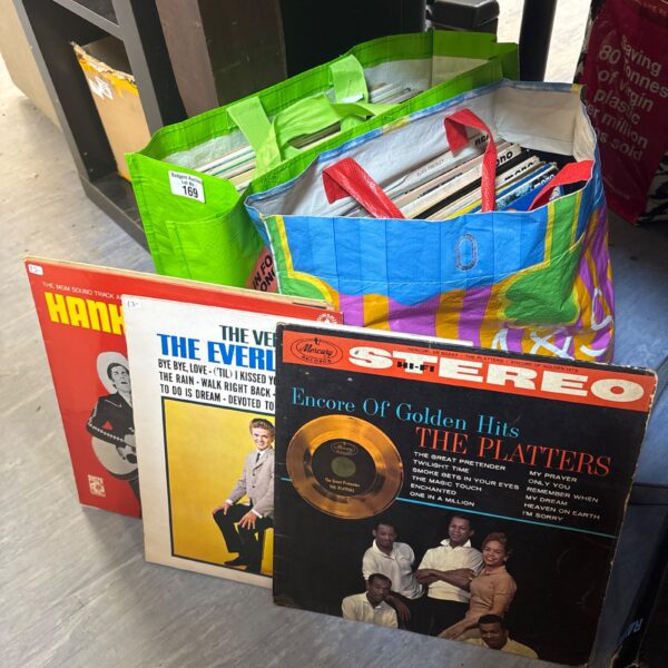 Mixed vinyl record lot in shopping bags.