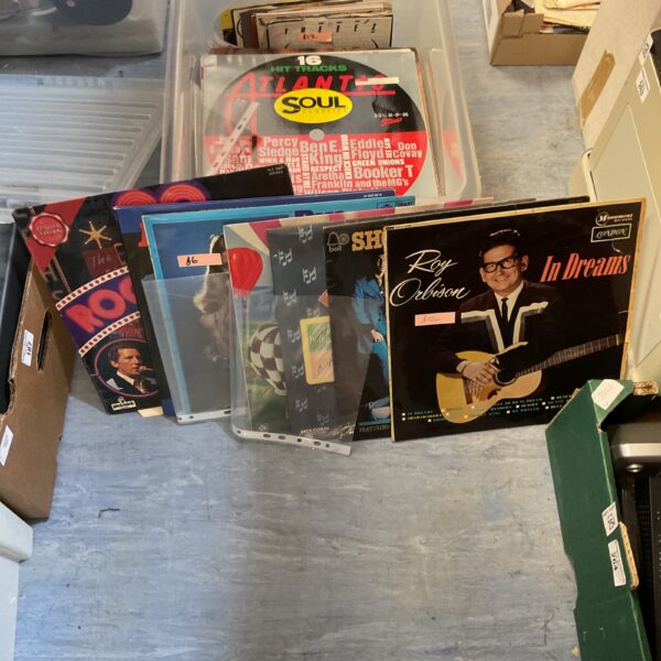 Mixed vinyl record lot in a plastic container.