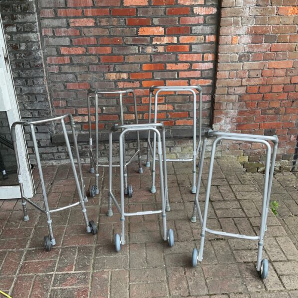 Lot of five aluminium walking frames for mobility assistance.