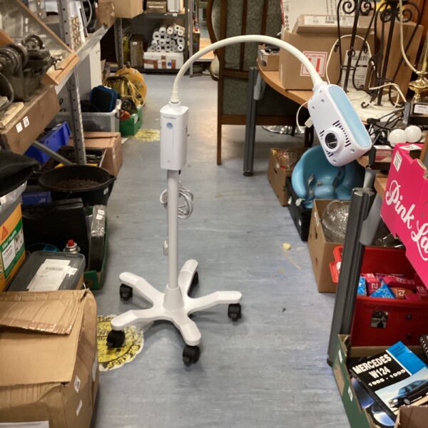 Welch Allyn examination light on a rolling base in a storage area.
