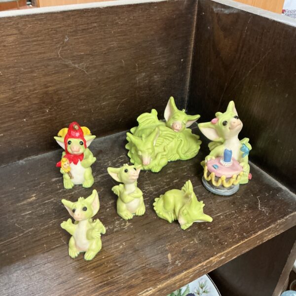 Collection of colourful whimsical dragon figures on a patterned surface.