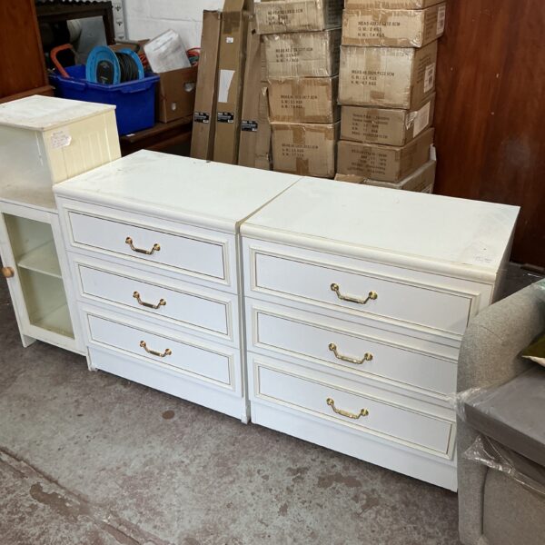 White bedroom cabinets with three drawers, offering storage solutions.