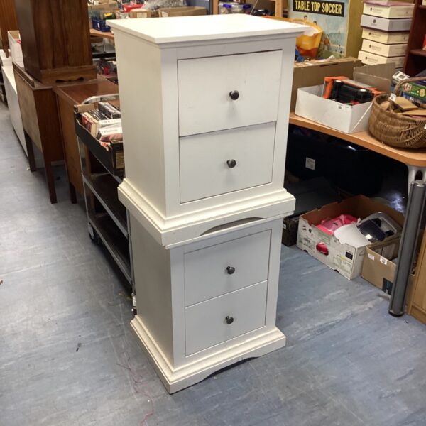 White two-drawer bedside cabinets for bedroom storage.