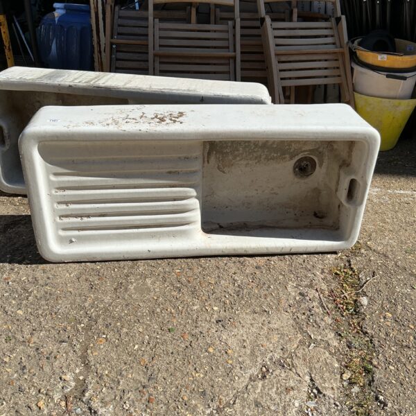 White ceramic Belfast sink repurposed as a garden planter.