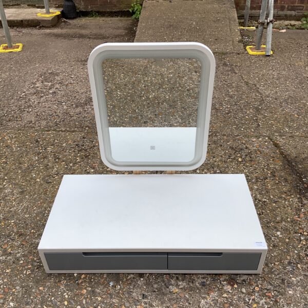 White lighted desktop mirror with drawer on a table.