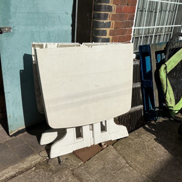 White plastic folding garden table for outdoor use.