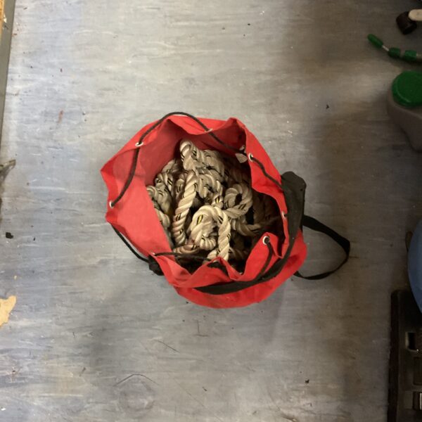 White rope coil neatly stored in a red bag.