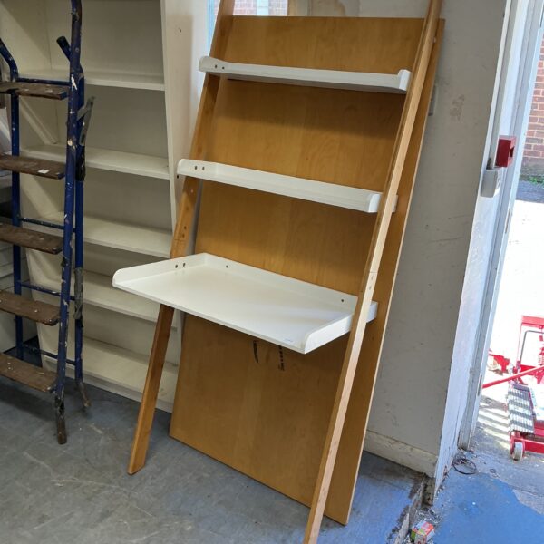 White wall-mounted shelving unit with ladder design for home storage.