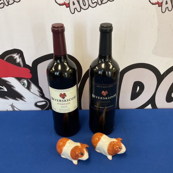 Unique wine bottle salt and pepper grinders with guinea pig figurines.