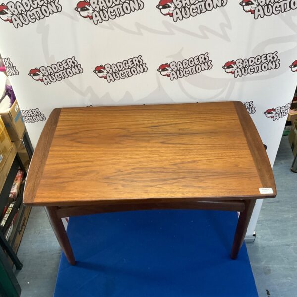 Vintage mid-century modern wooden coffee table in warm tones.