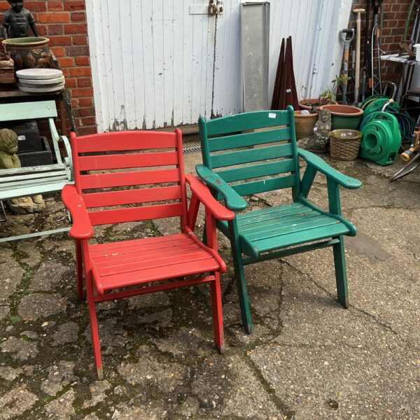 Pair of weathered wooden garden seats in a garden setting.