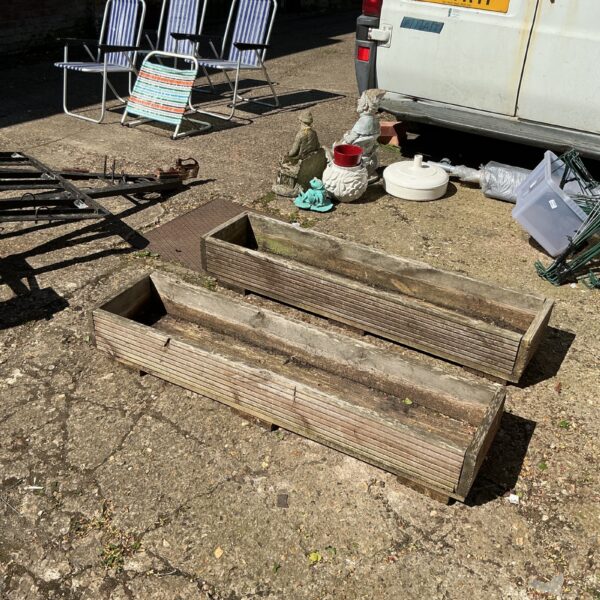 Pair of weathered wooden garden troughs for outdoor planting.
