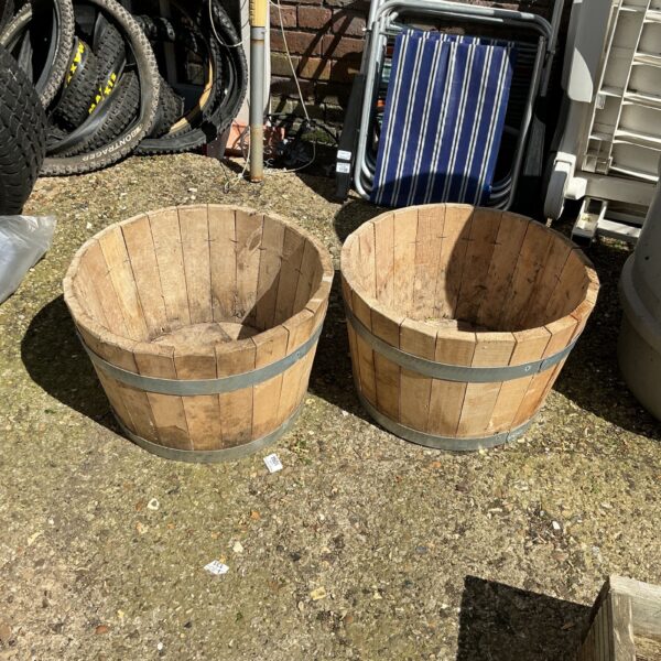 Pair of rustic wooden garden tubs for outdoor planting.