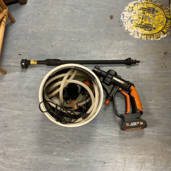 Worx Hydroshot 20V portable power cleaner with hose attached.