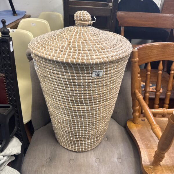 Large woven reed laundry basket with lid, vintage farmhouse style.
