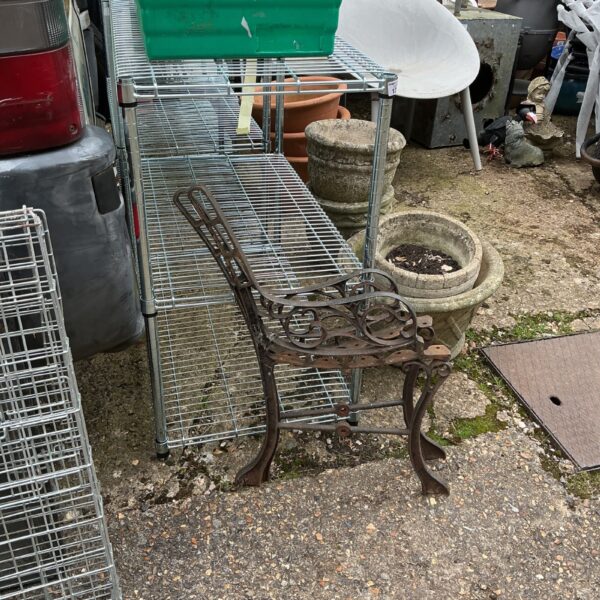 Ornate wrought iron bench ends in a garden setting.
