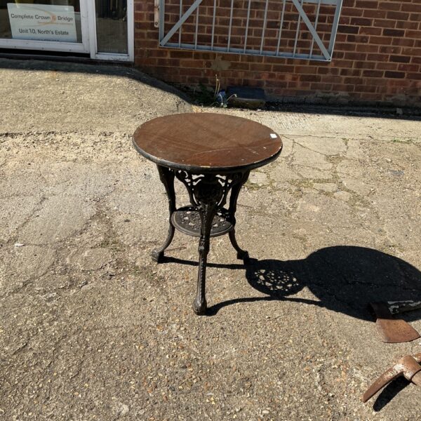 Vintage wrought iron garden table with paw feet.