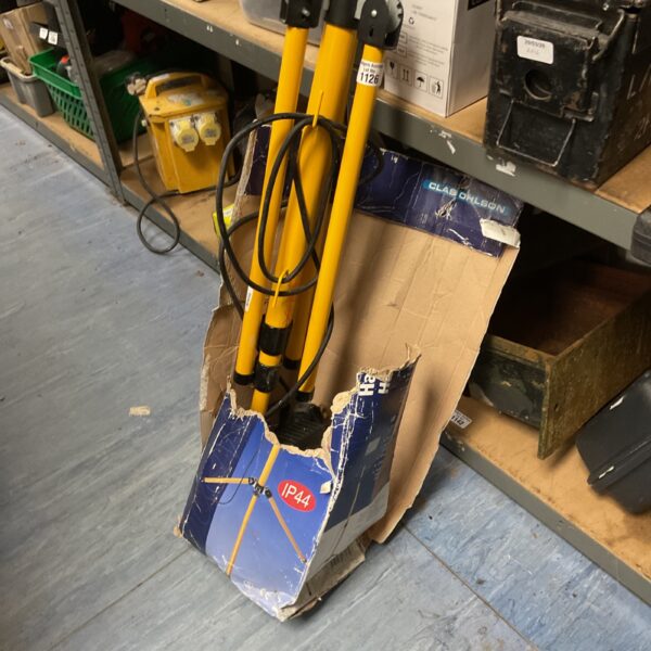 Yellow tripod-mounted LED work light with damaged packaging.