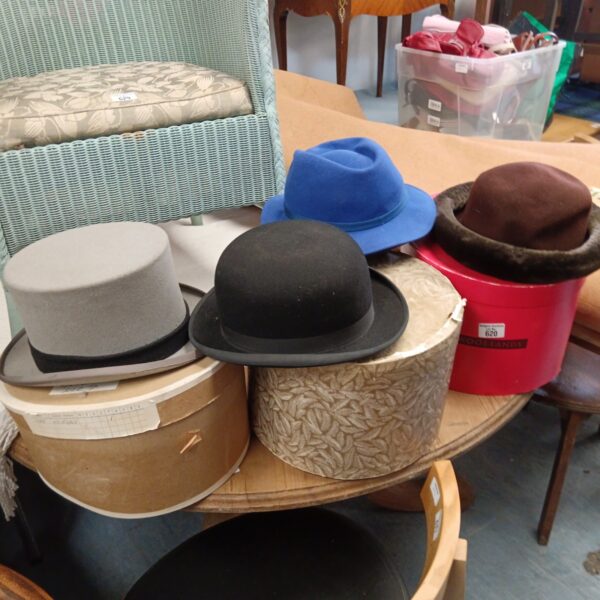 Three hat boxes with hats including moss bros top hat