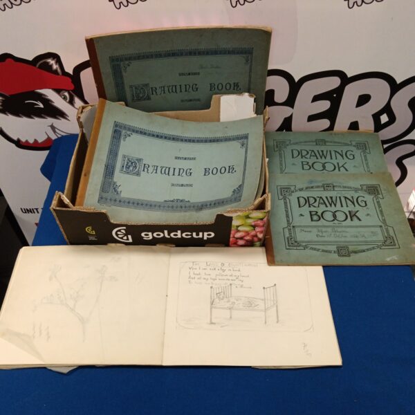 Stack of vintage 1920s school drawing books with embossed covers.