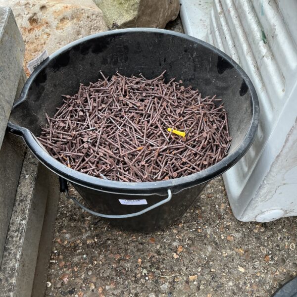 Bucket of 2-inch metal nails for construction and DIY projects.