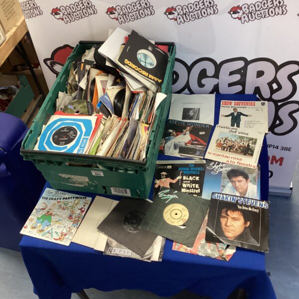 Collection of 7 inch vinyl records in a plastic crate.