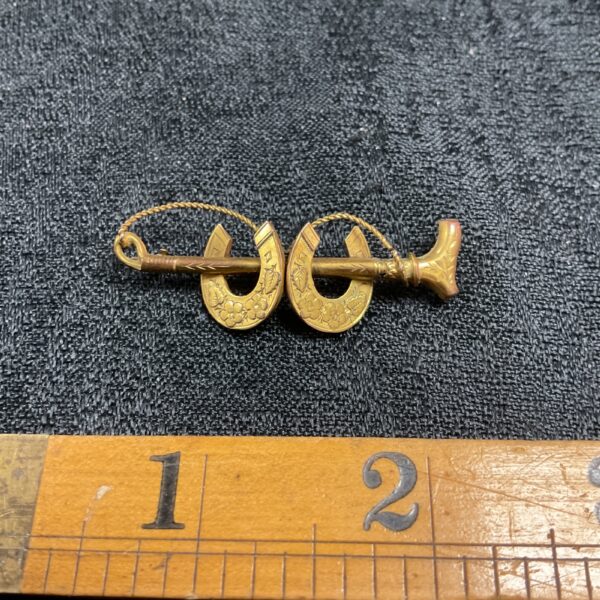 Vintage 9ct gold horse shoe brooch with riding crop detail.